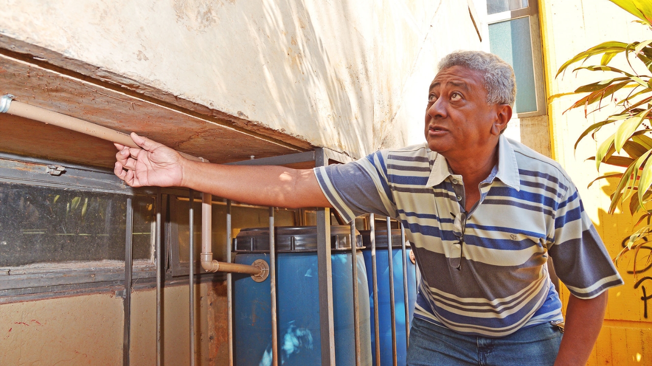 Euler Bueno, professor da UFG, mostra a tubulação e os reservatórios do sistema instalado no Crea-GO para captar e armazenar a água descartada por aparelhos de ar-condicionado, reaproveitada nos serviços de limpeza do prédio.