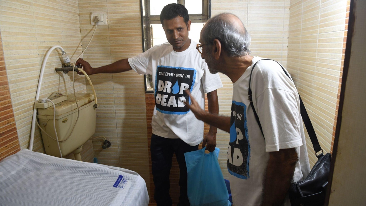 Aabid Surti, fundador da Drop Dead Foundation, acompanha a vistoria de um vazamento em apartamento durante uma das visitas de domingo, rotina em que pequenos reparos gratuitos em torneiras ajudaram a transformar gotas desperdiçadas em milhões de litros de água economizados.