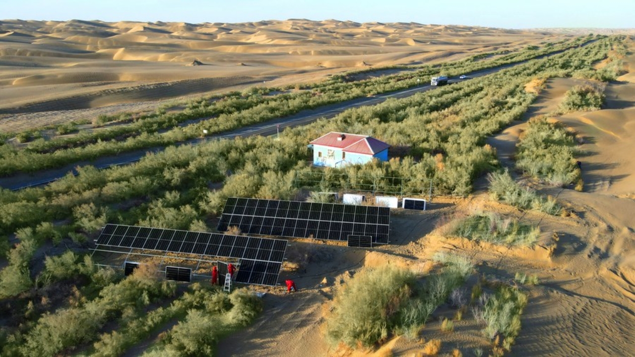 Foto aérea feita em 29 de maio de 2022 mostra trabalhadores da filial da PetroChina no campo petrolífero de Tarim instalando painéis fotovoltaicos em uma estação de poço ao longo da Rodovia do Deserto de Tarim, na Região Autônoma Uigur de Xinjiang, no noroeste da China. (Foto: Xinhua)
