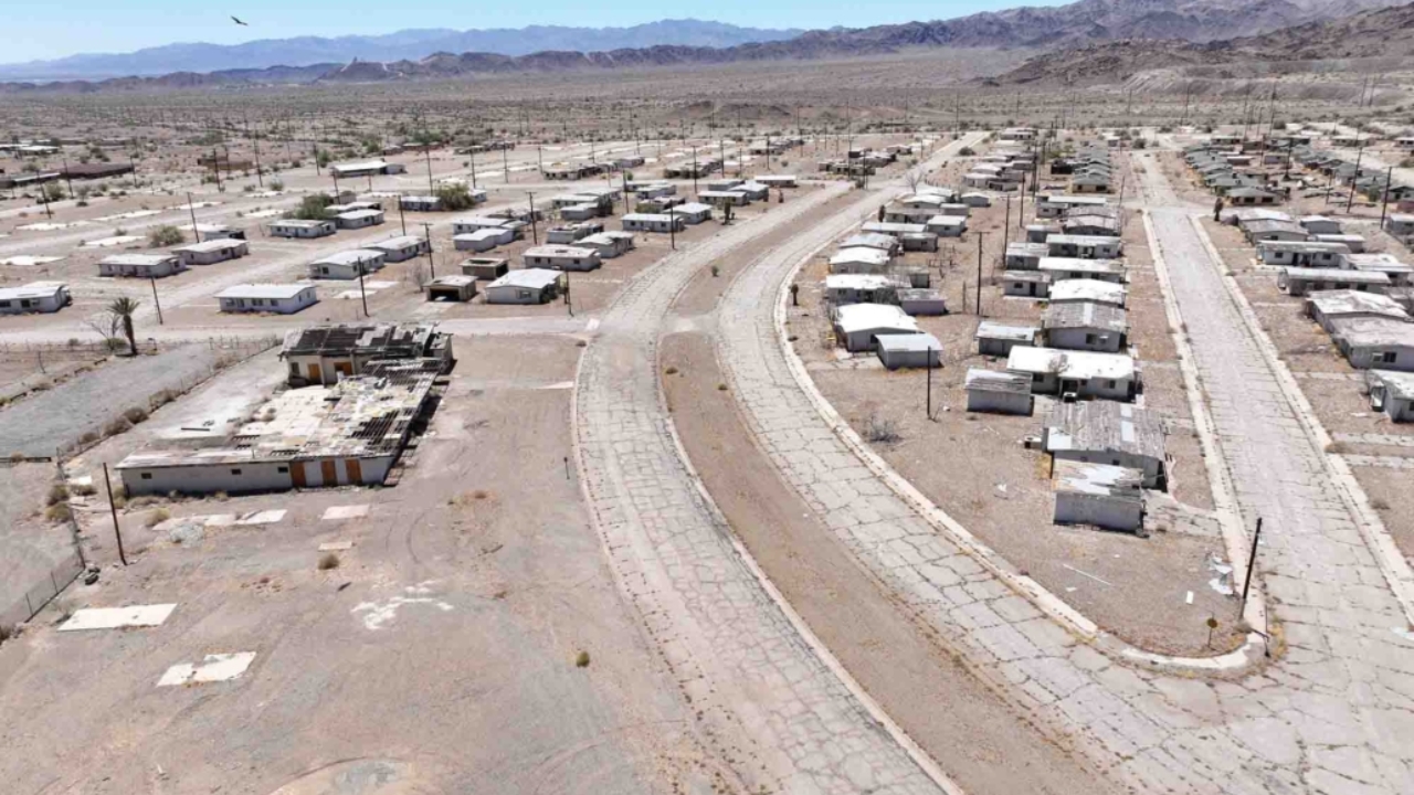 Vista aérea de Eagle Mountain, antiga cidade mineradora no deserto da Califórnia que chegou a abrigar milhares de moradores e hoje tem suas ruas vazias reaproveitadas em treinamentos com drones para operações de segurança pública e emergência.