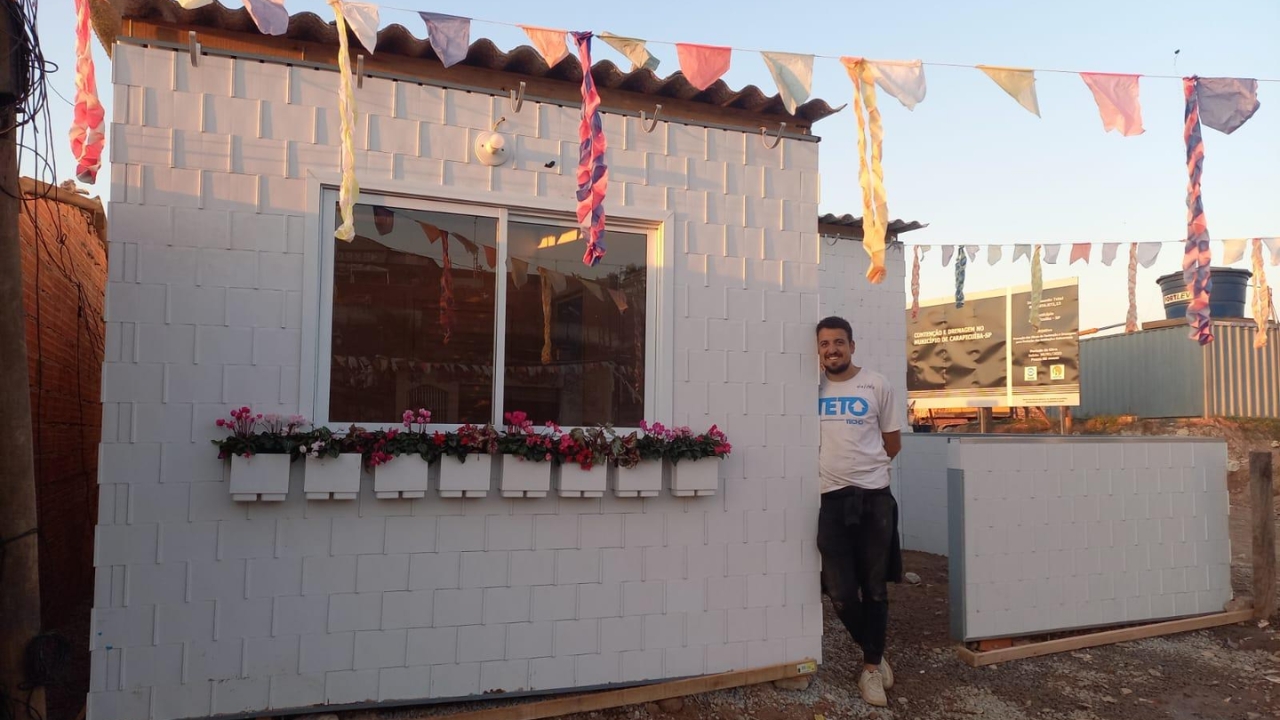 Casa sustentável construída com blocos de plástico reciclado aparece finalizada em São Paulo, com fachada branca, floreiras e estrutura modular. O projeto da TETO Brasil mostra como resíduos reaproveitados podem virar moradia social com montagem rápida e menor geração de entulho.