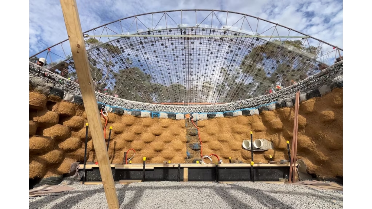 Estrutura interna de uma Earthship mostra o uso de pneus, garrafas e latas reaproveitadas na construção, combinando terra compactada e materiais reciclados para criar uma moradia mais sustentável e resistente. Crédito: Joan Pahissa.