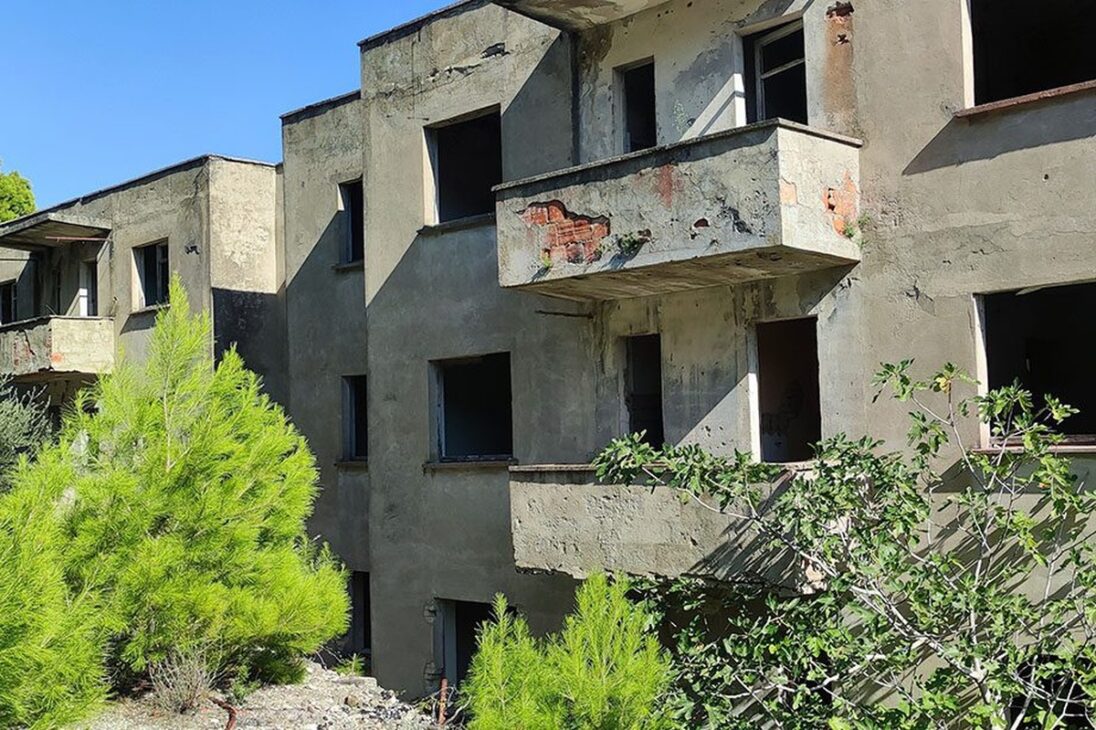Edificação militar abandonada e tomada pela vegetação na ilha de Sazan, na Albânia, remanescente do período em que o território abrigou instalações estratégicas, bunkers e estruturas de defesa durante o regime de Enver Hoxha.