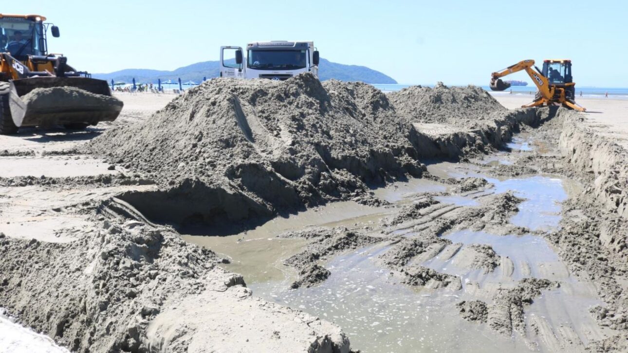 Ressaca em Santos acumula areia nos canais da orla e exige desassoreamento com máquinas para evitar alagamentos. (Imagem: Raimundo Rosa/Prefeitura de Santos).