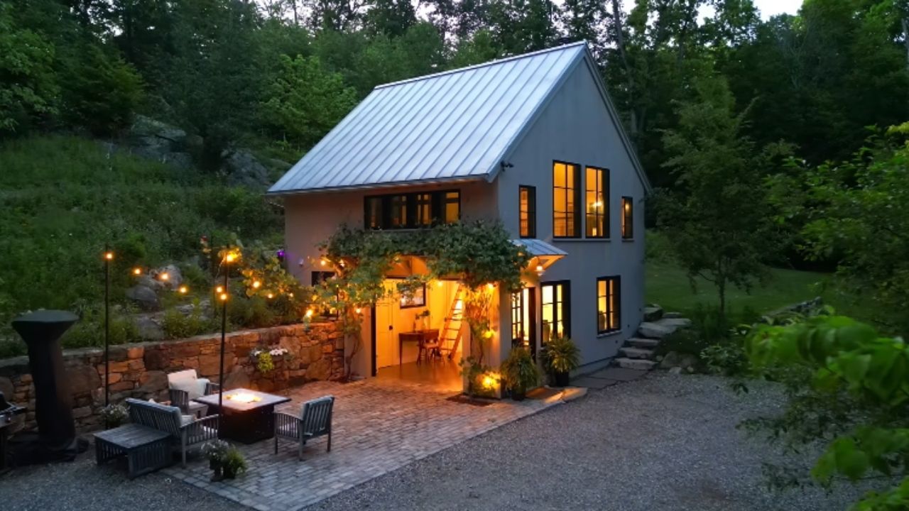 A mini casa em Connecticut nasceu de garagem e ganhou sauna, rio e móveis escondidos em refúgio compacto de 700 pés quadrados.