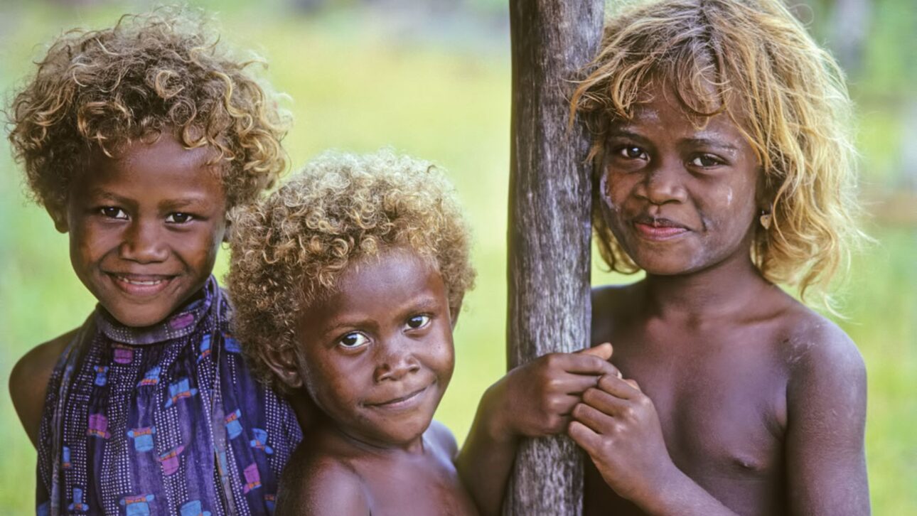 Os melanésios das Ilhas Salomão têm pele escura e cabelos loiros naturais, e a ciência aponta uma mutação genética própria, não herança europeia, como causa.