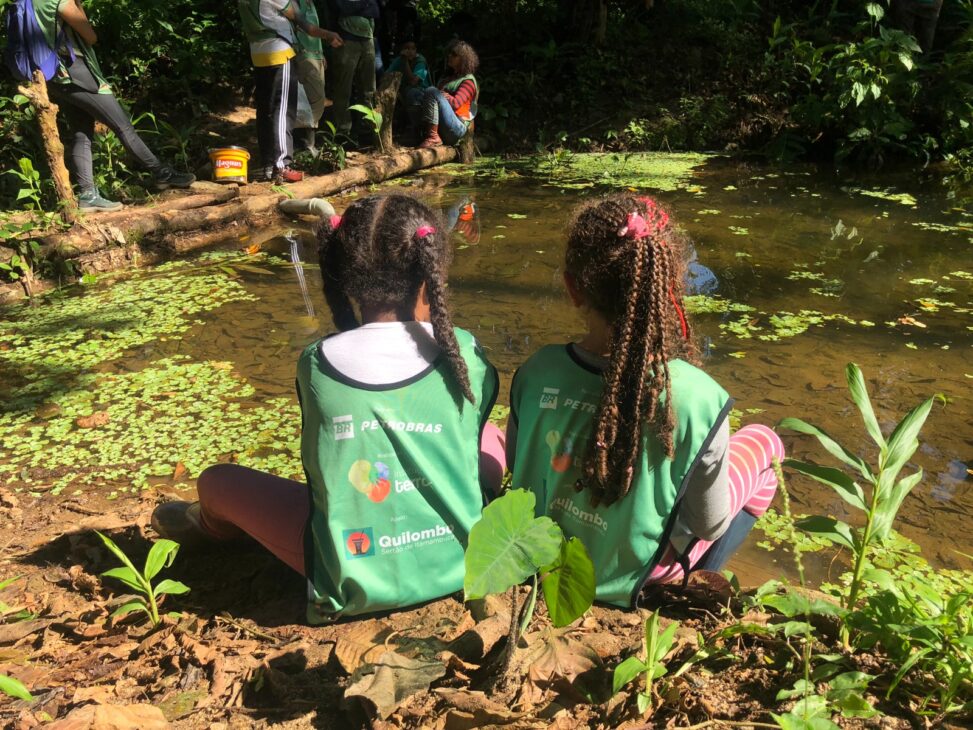 Crianças de uma comunidade quilombola participam de atividade de educação ambiental às margens de um curso d’água durante ação do Projeto Quilombo Sustentável apoiado pela Petrobras.