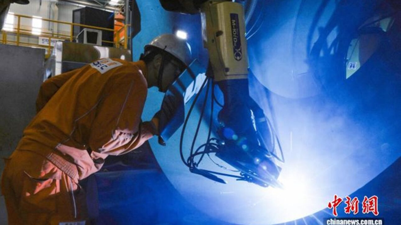 A China colocou em operação seu primeiro sistema de robô de soldagem inteligente desenvolvido internamente para manufatura flexível na engenharia naval em Tianjin, em 14 de junho de 2026. A foto mostra um engenheiro realizando verificações pontuais no local sobre o desempenho operacional do robô de soldagem. Foto: Captura de tela de chinanews.com.cn