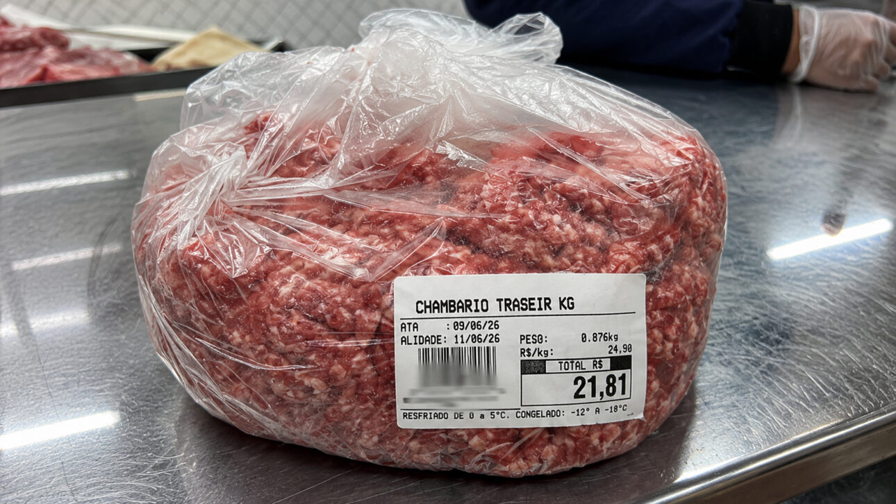 Pacote de carne moída embalado sobre bancada de aço inox em setor de açougue, ilustrando fiscalização que identificou moagem antecipada do produto em supermercado da Bahia.