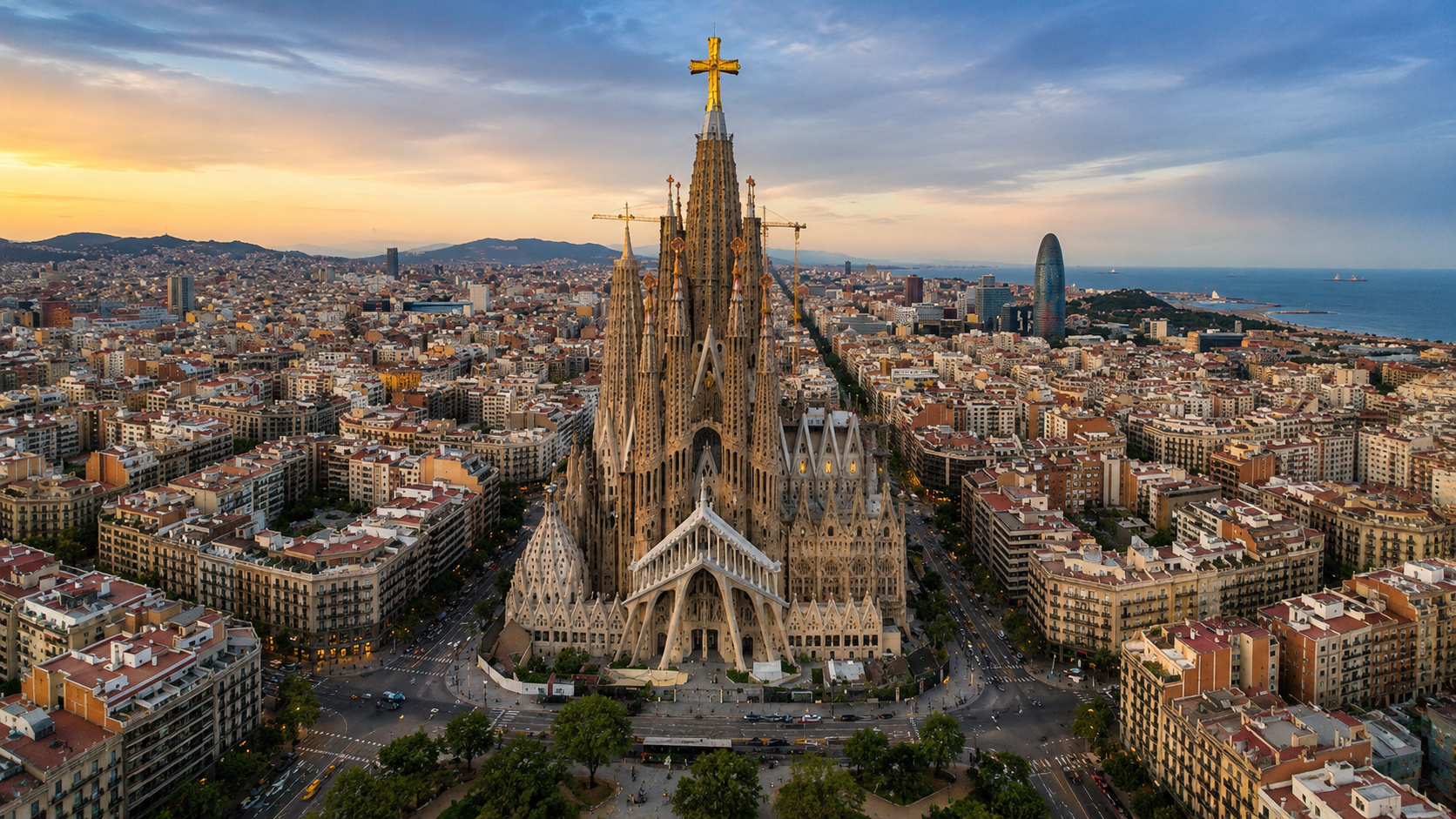 Vista aérea da Sagrada Família com a torre de Jesus Cristo elevada sobre Barcelona ao pôr do sol