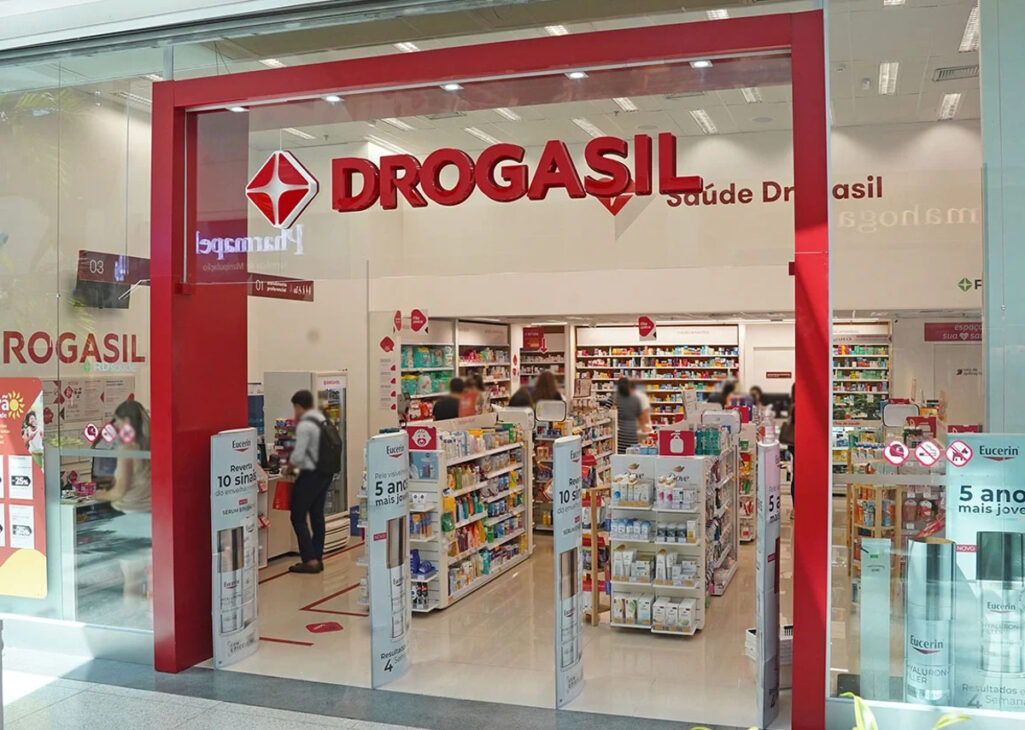 Fachada de una tienda de Drogasil con clientes circulando por los pasillos, en imagen relacionada a la condena de la cadena por vincular descuentos al suministro de CPF.