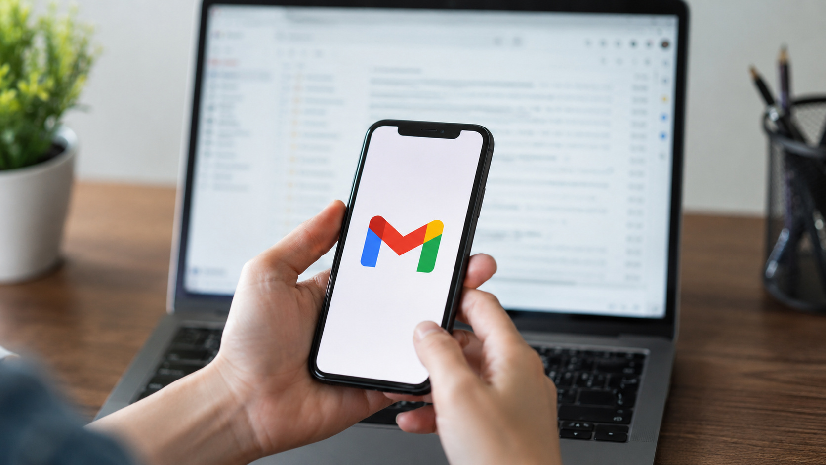 Pessoa segurando smartphone com o Gmail aberto, representando a mudança de endereço de e-mail da Conta Google sem perda de mensagens, fotos e arquivos.