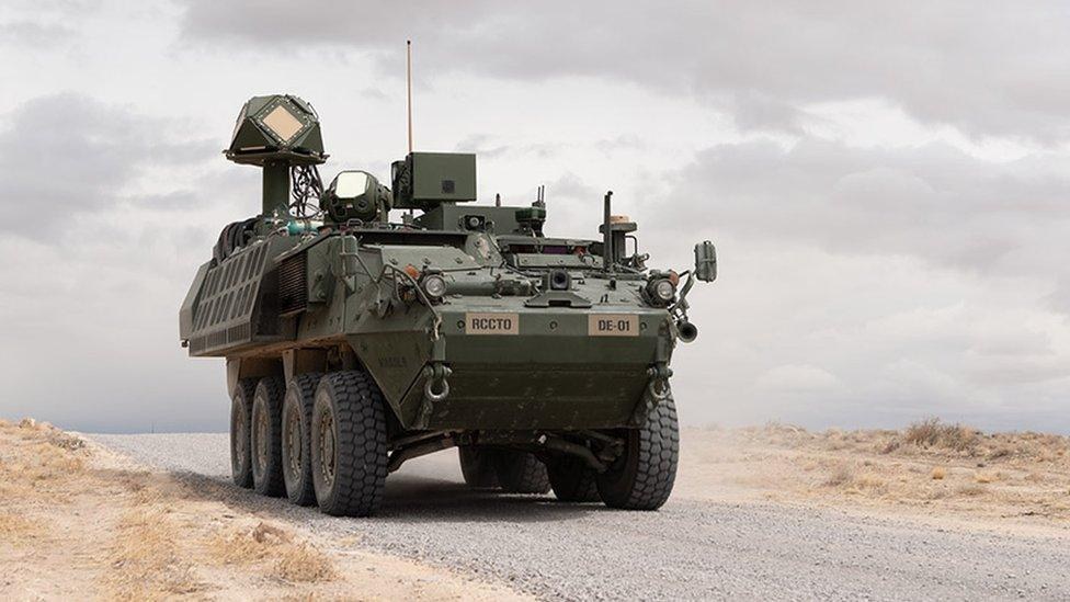 Veículo militar em terreno árido com sistema de arma de energia dirigida