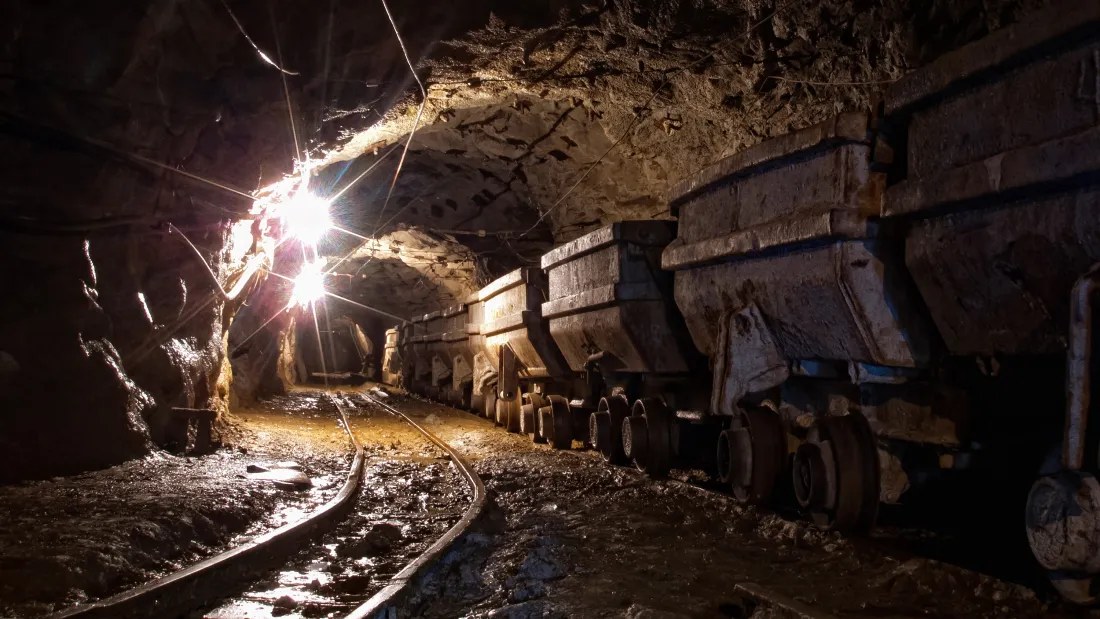 Equipamento de mineração em galeria subterrânea iluminada