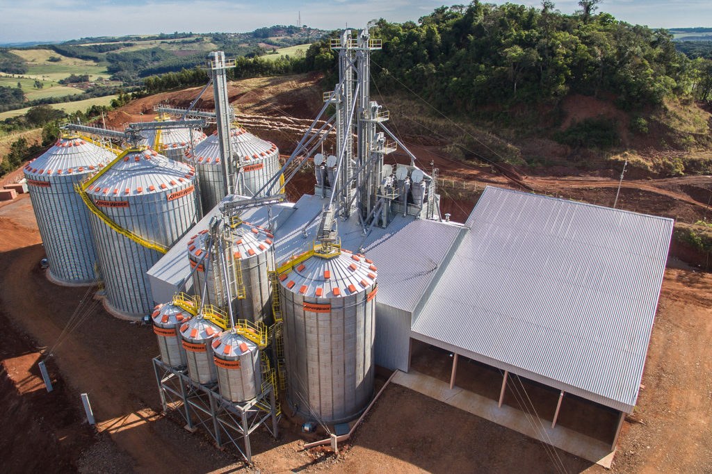 Caminhão recebendo grãos durante a colheita no campo
