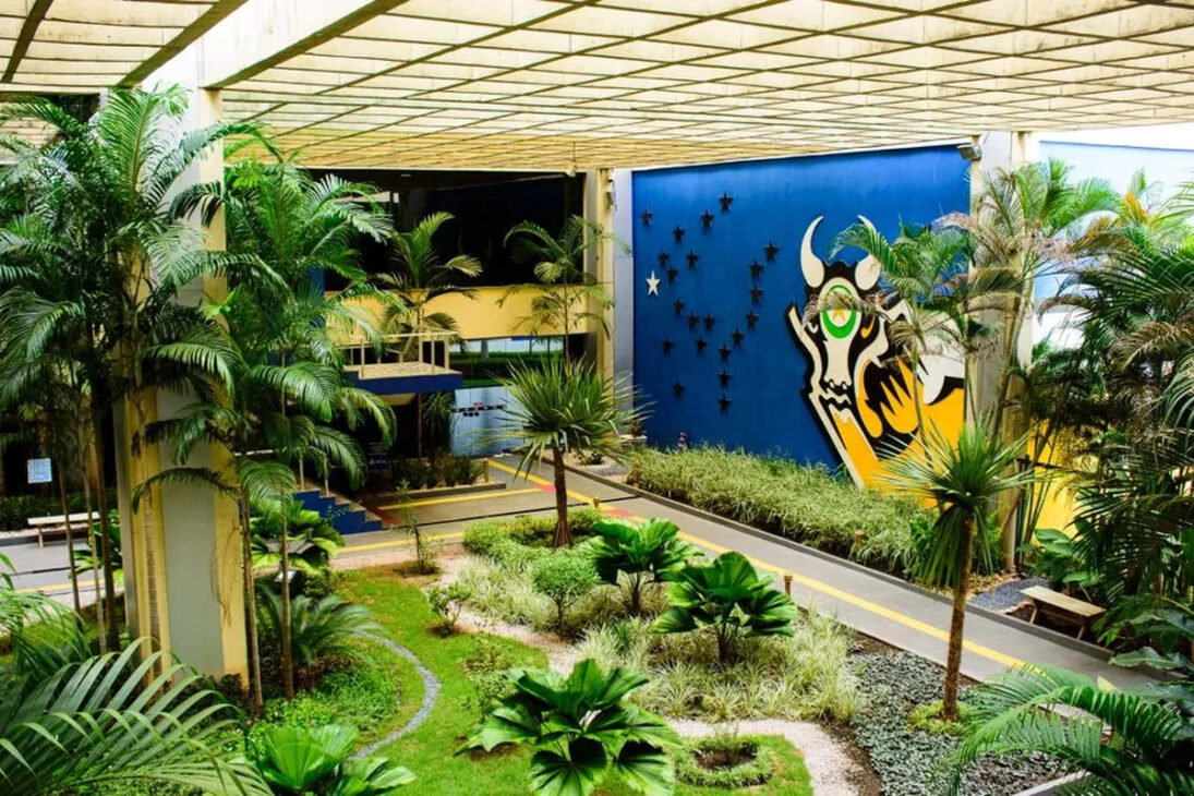 Área interna do Palácio Paiaguás, sede do Governo de Mato Grosso em Cuiabá, com jardins tropicais e painel artístico que representa símbolos do estado.