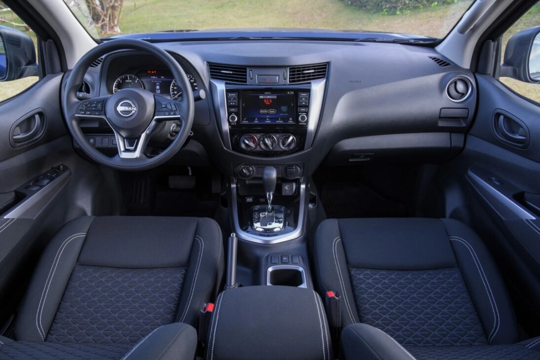 Interior of the Nissan Frontier Attack 2026 with dashboard, multifunction steering wheel, 8-inch multimedia center, automatic transmission, and seats with Zero Gravity technology.