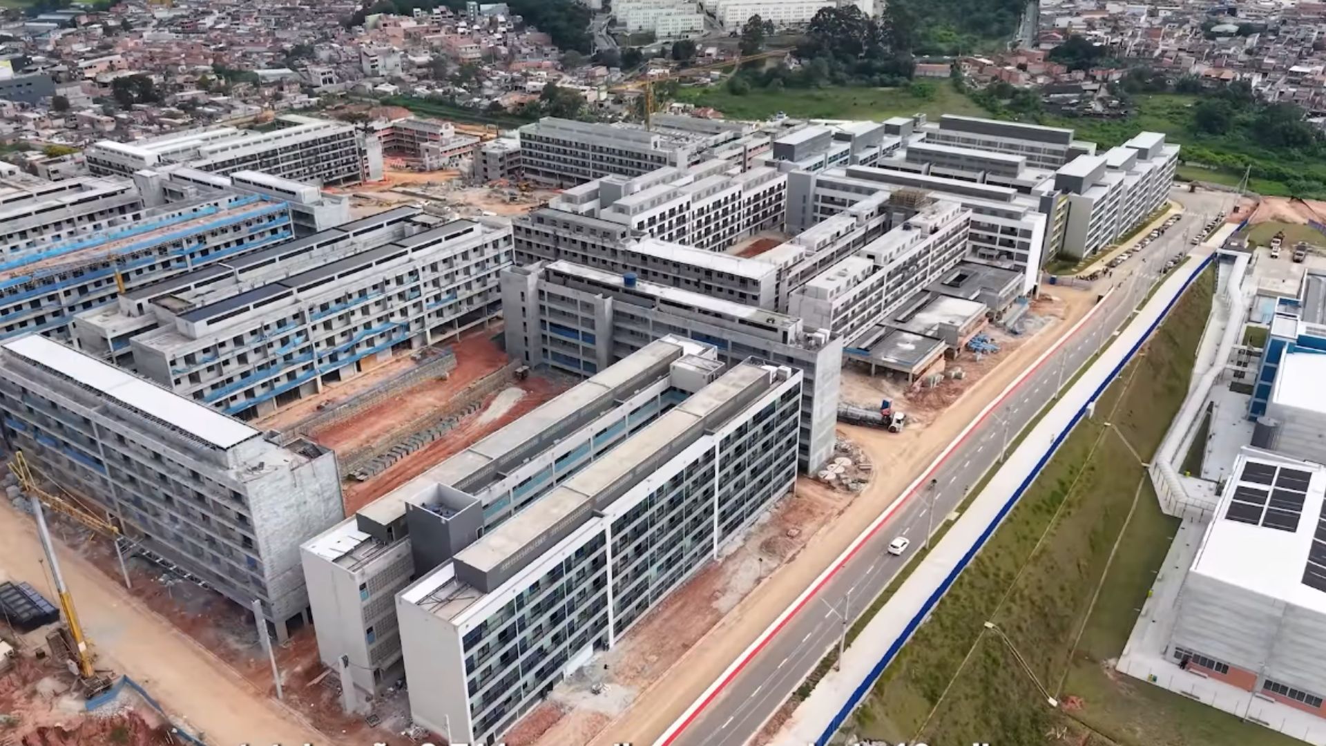 Fachada de unidade básica de saúde moderna com conjunto residencial ao fundo em dia claro