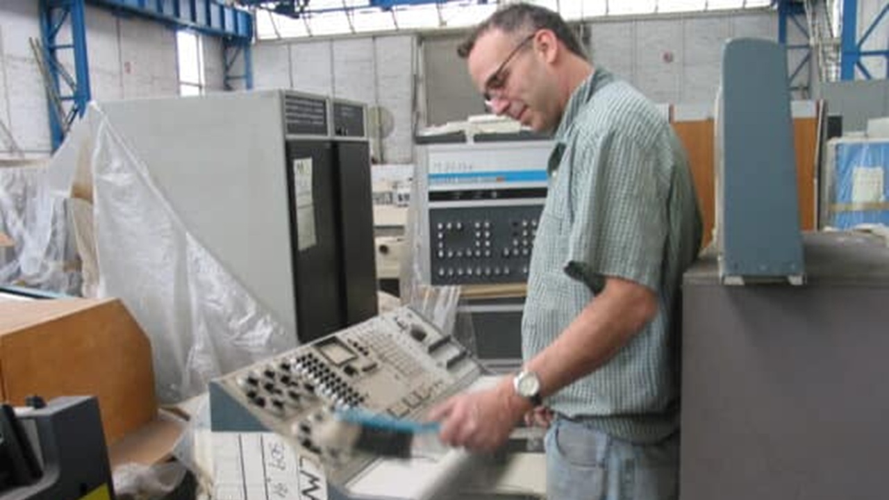 O curador sênior do CHM, Dag Spicer, limpando o painel de controle de um computador analógico. Dag e seu colega curador do CHM, Alex Bochannek, ficaram especialmente satisfeitos ao ver vários sistemas de computadores analógicos e analógico-híbridos muito importantes na coleção.