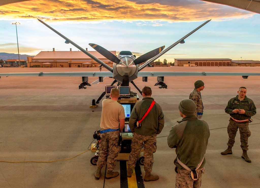 Drone militar em operação ao pôr do sol numa base aérea