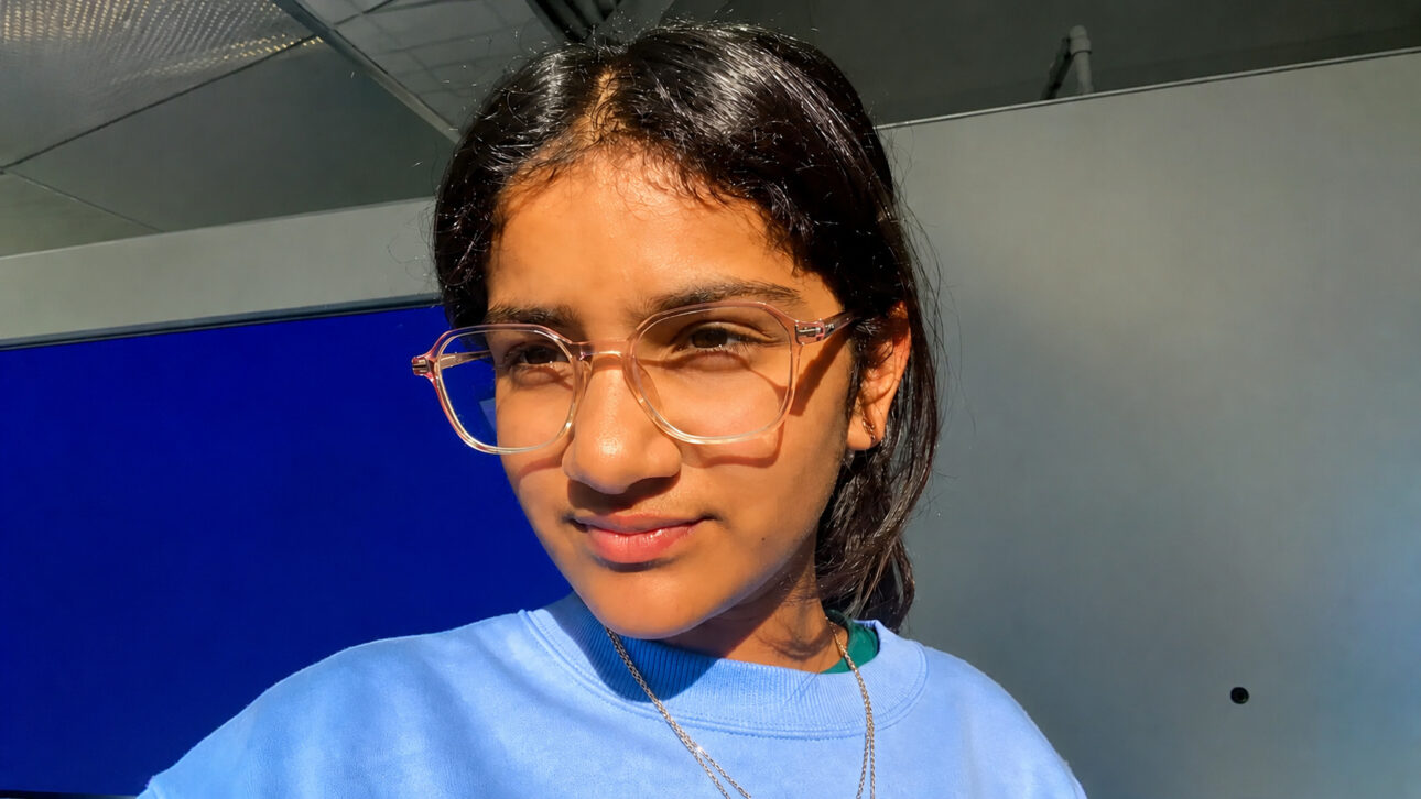 Mana Jampala, de 12 anos, criadora da recepcionista virtual Voxa, posa em ambiente interno após desenvolver uma solução de inteligência artificial para pequenas empresas.