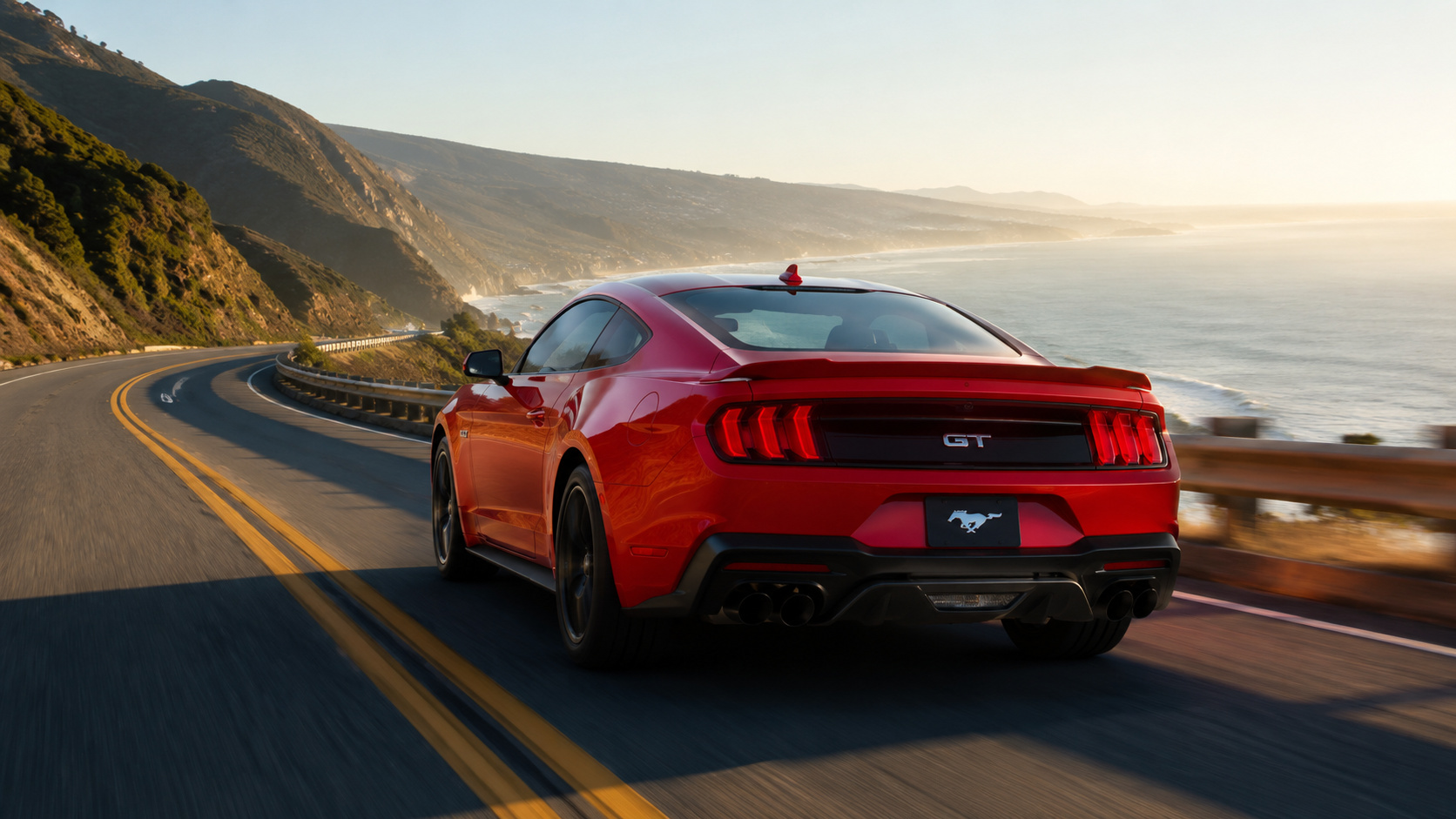 Ford Mustang vermelho em movimento por estrada litorânea, modelo incluído em recall por falha nos limpadores do para-brisa.
