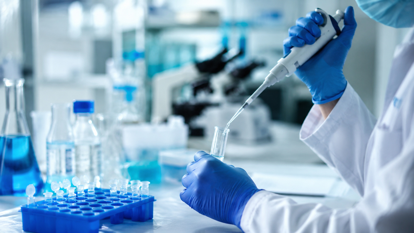 Pesquisador manipula pipeta e tubo de ensaio em laboratório de biotecnologia durante estudos para desenvolvimento de Insumos Farmacêuticos Ativos (IFAs) a partir da biodiversidade brasileira.