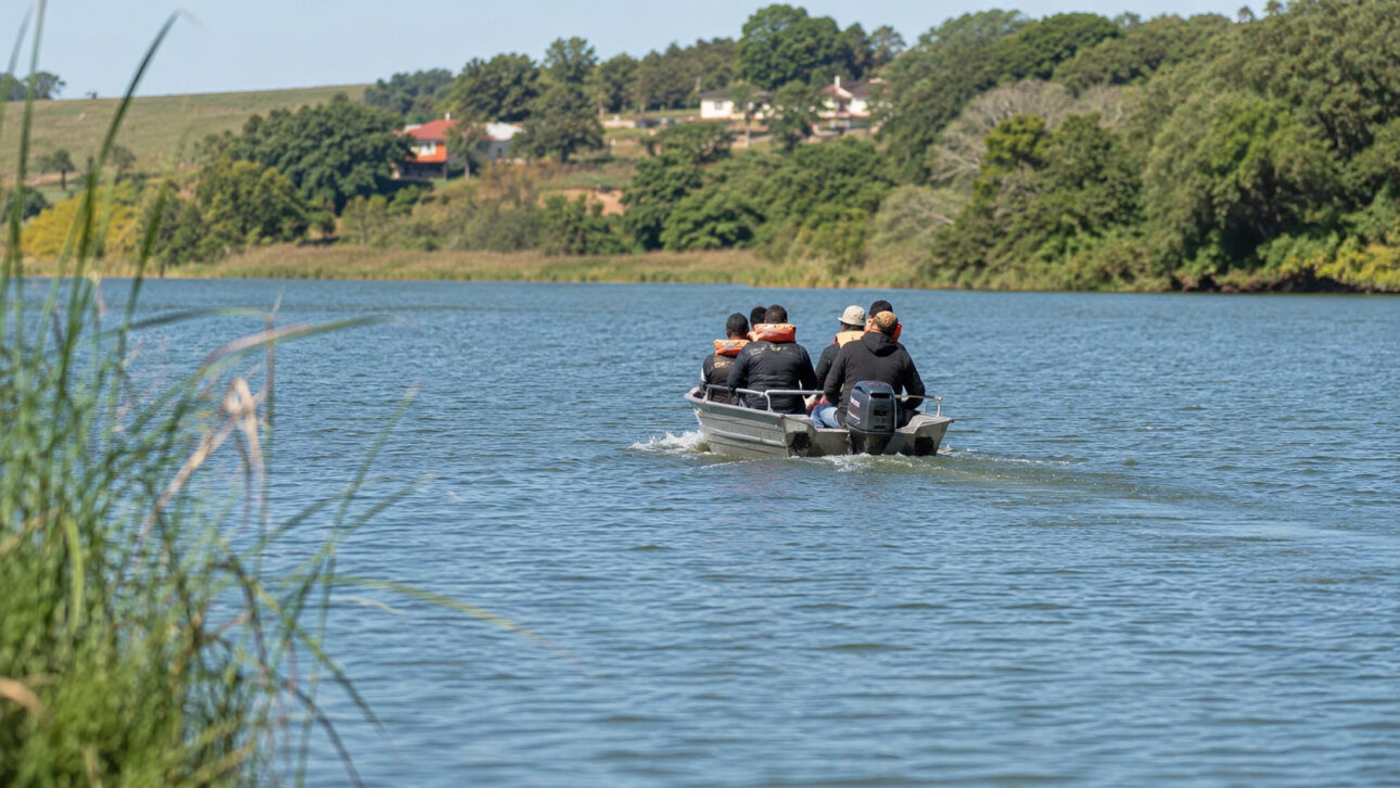 Barco com equipe de monitoramento ambiental navega pelo Rio Tietê durante estudo sobre contaminação da água por agrotóxicos e microplásticos.