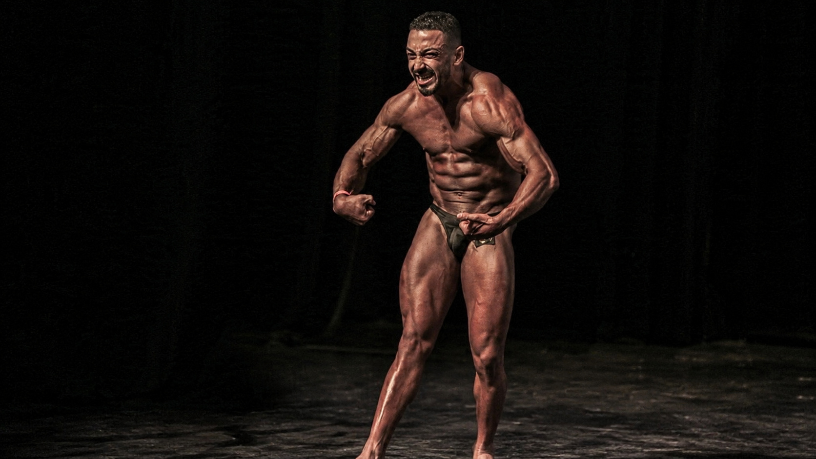 Fisiculturista Alex de Souza Luz, conhecido como Lekão, posa durante competição de fisiculturismo em palco, após conquistar o título de campeão mesmo convivendo com paralisia cerebral.