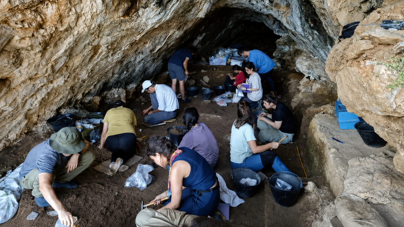 Escavação arqueológica em caverna na Turquia, com pesquisadores analisando sedimentos em busca de evidências sobre neandertais e Homo sapiens.