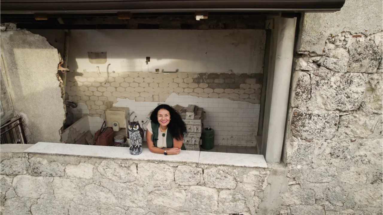 A brasileira Rubia Daniels posa em uma antiga casa de pedra em reforma na Sicília, onde imóveis vendidos por 1 euro seguem atraindo estrangeiros dispostos a transformar ruínas abandonadas em novos lares na Itália. Fonte: CNBC Make It.