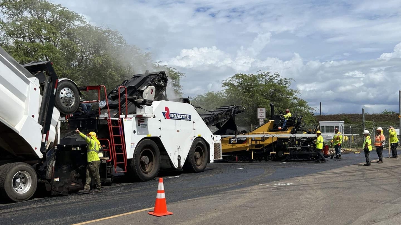 Workers apply asphalt on an experimental section in Hawaii, where researchers test a mixture with recycled household plastic and abandoned fishing nets to transform hard-to-reuse waste into urban pavement.