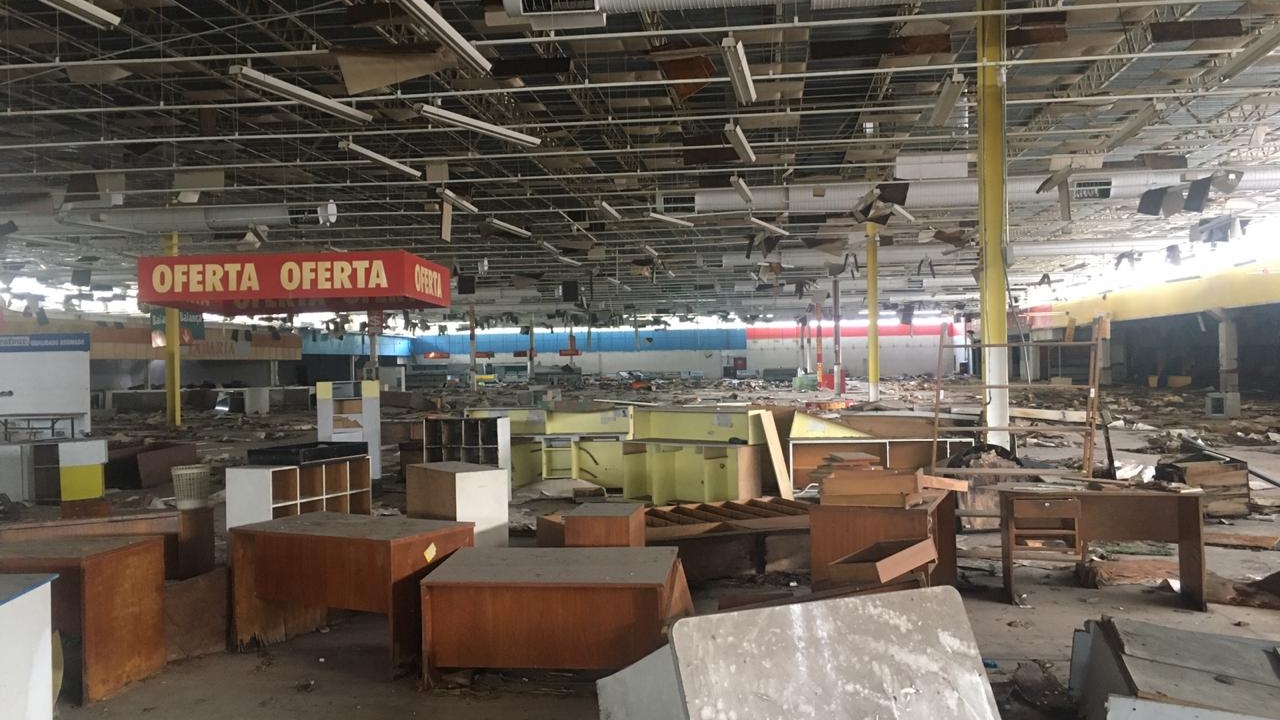 Interior do antigo Carrefour da Usina mostra balcões, placas e estruturas abandonadas após o fechamento da unidade na Tijuca, que ficou desativada desde 2005 e agora deve dar lugar a um condomínio habitacional com cerca de 600 moradias. Imagem: Reprodução.