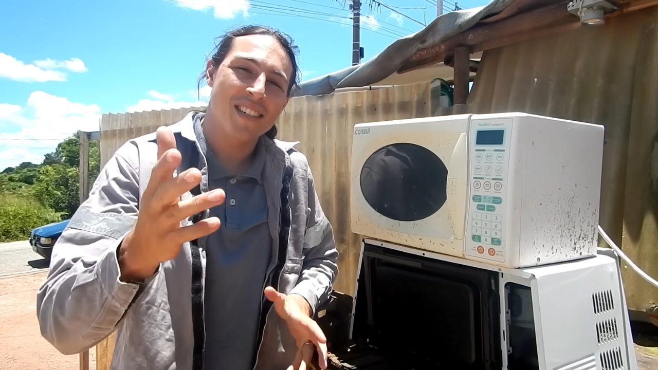 Criador mostra dois micro-ondas velhos usados como base para reaproveitar transformadores e montar uma máquina de solda caseira capaz de unir pequenas peças de metal em testes de bancada.