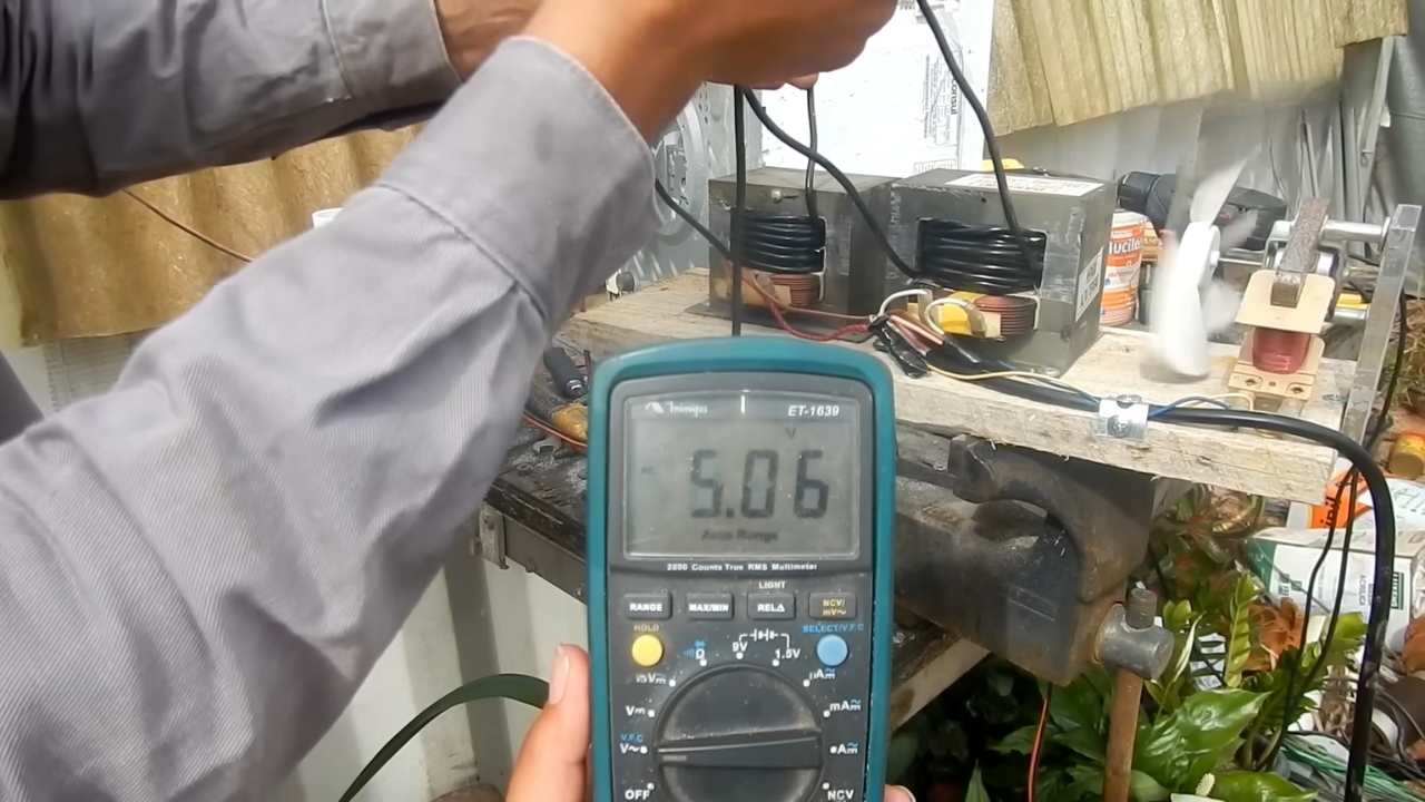 Multímetro registra cerca de 5 volts durante uma etapa de ajuste dos transformadores, quando as bobinas ainda não estavam somando tensão corretamente na montagem da máquina de solda caseira. Fonte: LetraJota/Reprodução.