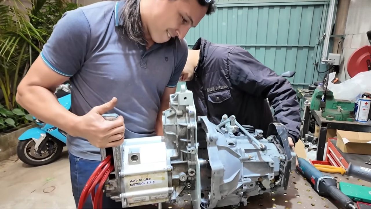 Motor elétrico rebobinado é acoplado ao câmbio manual do Fiat Uno durante a montagem do projeto caseiro de conversão elétrica. Fonte: canal LetraJota/YouTube.