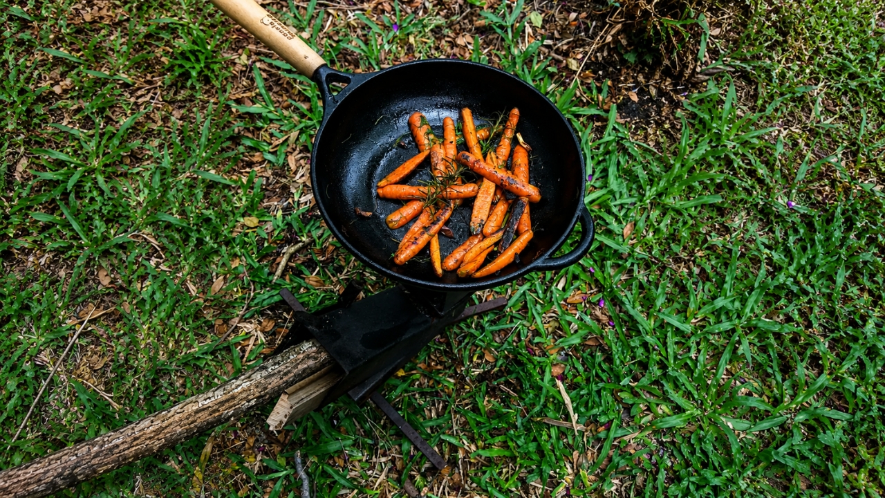 Cenouras preparadas em fogão rocket no aniversário de 36 anos de Luísa Matsushita ajudam a traduzir a rotina em Garopaba, marcada por alimentação vegana, preparo ao ar livre, cultivo no terreno e soluções simples de baixo impacto. Foto: cortesia de Luísa Matsushita
