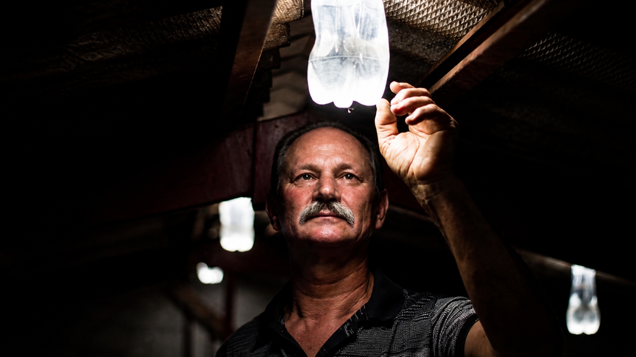 Mecânico brasileiro colocou água e cloro dentro de uma garrafa PET, furou o telhado da própria oficina escura e criou uma lâmpada solar simples que imita até 60 watts durante o dia