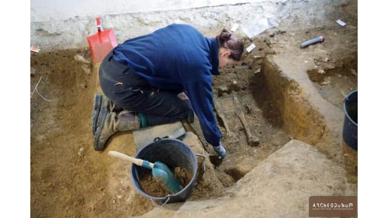 Um arqueólogo escava uma antiga sepultura no porão de Corbeil-Essonnes. Foto de Archeodunum.