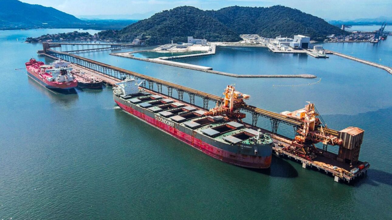 Máquinas gigantes no Porto Sudeste movem minério de ferro entre vagões, correias e navios em Itaguaí, com operação de 12.000 t/h real.