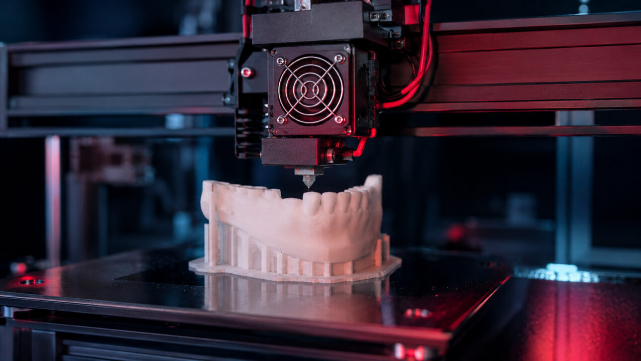 3D printer producing a jaw model in a laboratory, representing advances in additive manufacturing in medicine.