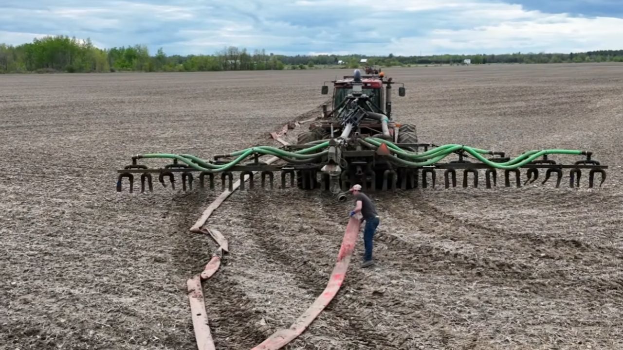 Esterco de fazenda leiteira vira adubo com tratores e bomba industrial em operação que mostra manejo pesado no campo.