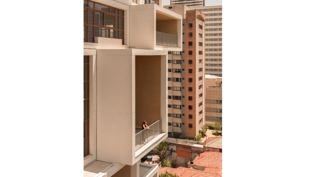 O edifício é revestido com pequenas telhas brancas.