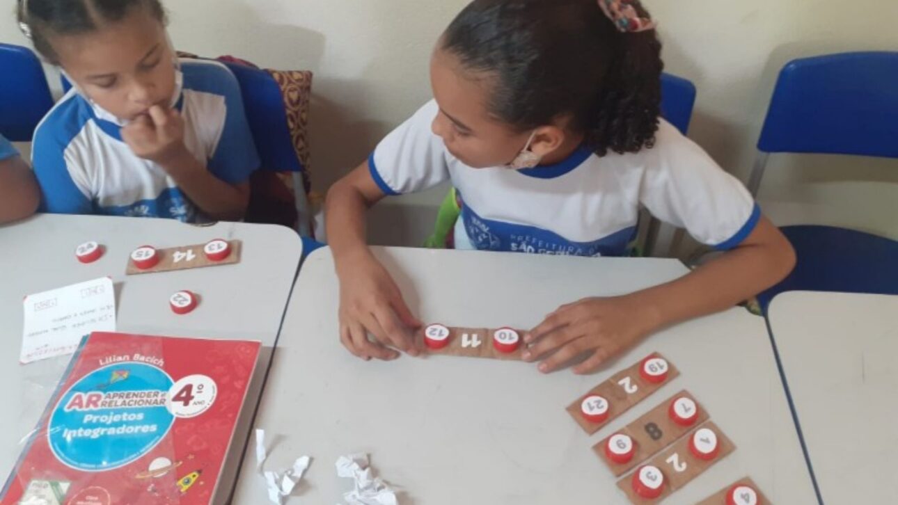 Crianças usam brinquedos criados com materiais recicláveis durante aulas em escola municipal