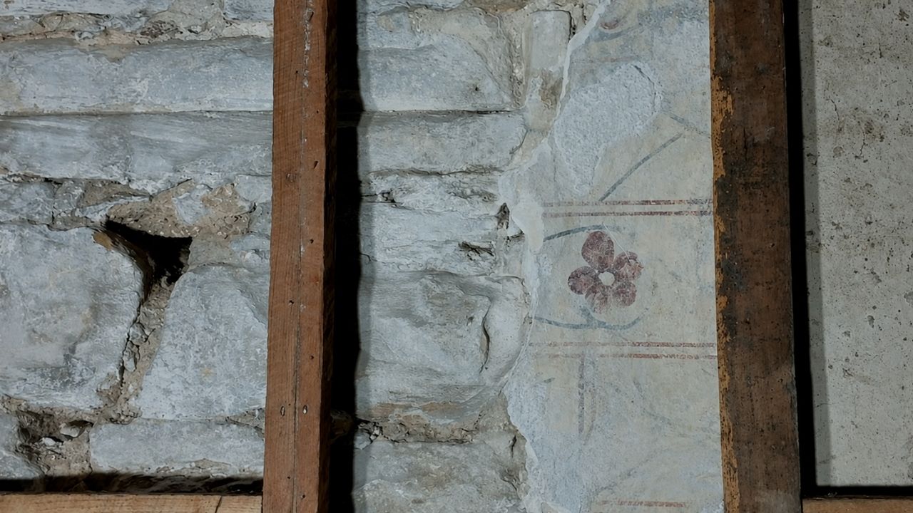 Medieval mural painting in Durham Castle reveals red flower, blocked windows, and zigzag crack hidden for centuries.