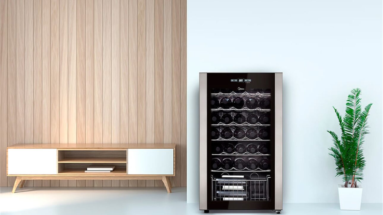 Adega climatizada Midea com porta de vidro e painel de controle, exibindo as garrafas deitadas nas prateleiras internas. (Foto: Divulgação/Midea)