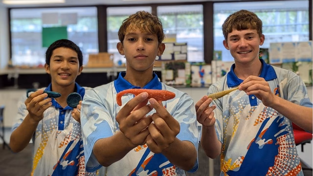 Kian, Khadim e Tye apresentam protótipos das Biolures, iscas desenvolvidas com gelatina, glicerina e água para substituir modelos convencionais de plástico. Crédito: Reprodução/NT News – Dripstone Middle School.