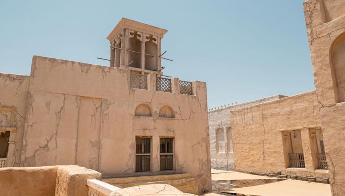 Torre badgir sobre casa de adobe em área desértica, usada para captar vento e resfriar ambientes sem eletricidade.