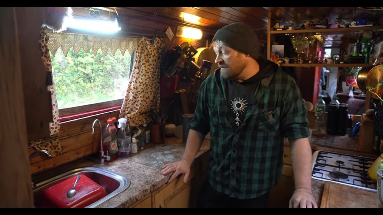 O interior de madeira do barco-casa, onde ficam a cozinha e o fogão a bordo.