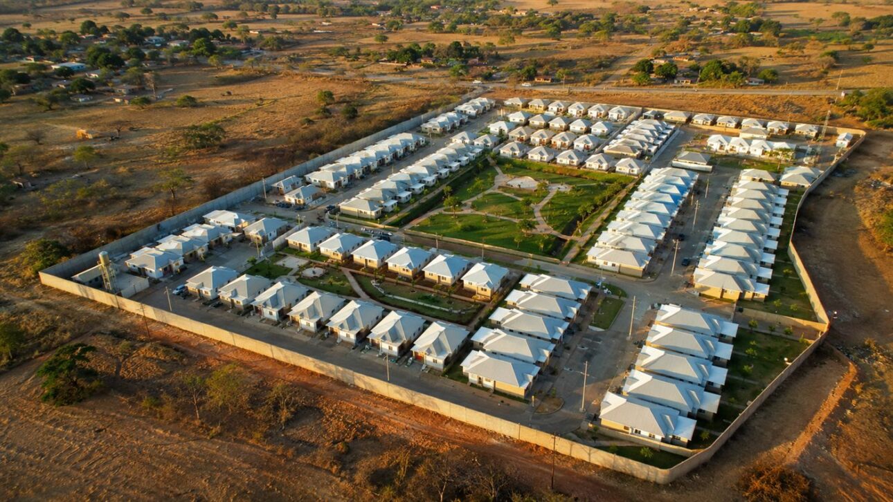 Aerial view of a set of light-roofed semi-detached houses organized in symmetrical blocks with central green areas. (illustrative image)